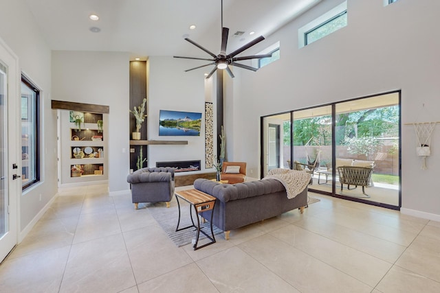 living room featuring ceiling fan, a towering ceiling, and light tile patterned floors