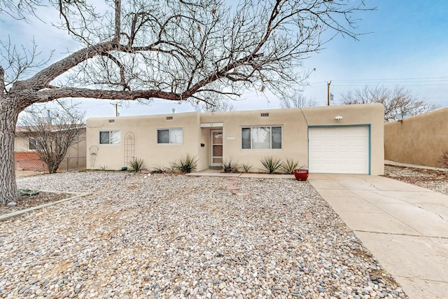 pueblo revival-style home with a garage