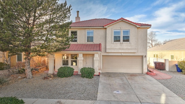 mediterranean / spanish house featuring a garage, a tile roof, concrete driveway, stucco siding, and a chimney