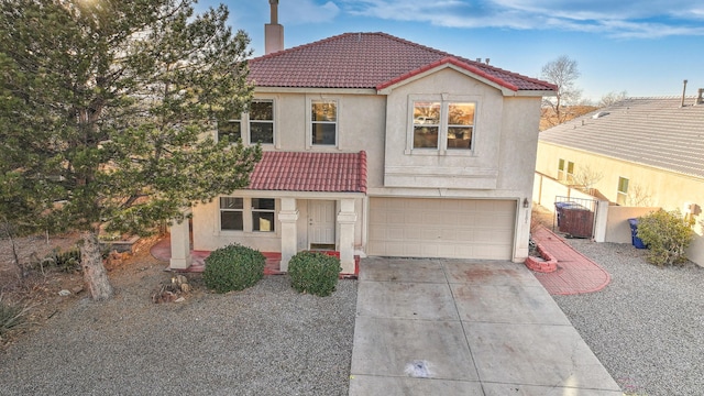 mediterranean / spanish home featuring a tiled roof, a chimney, driveway, and stucco siding