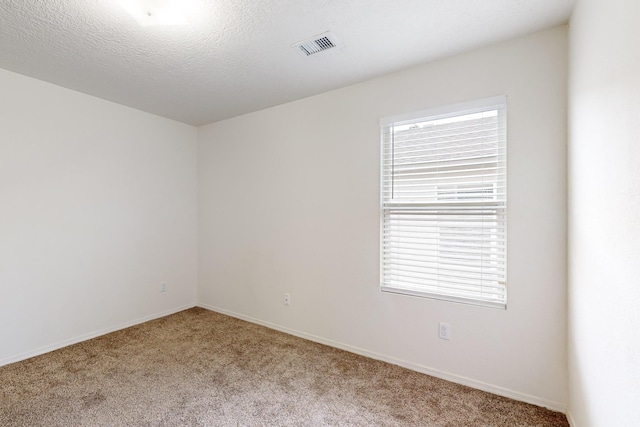 carpeted spare room featuring a textured ceiling