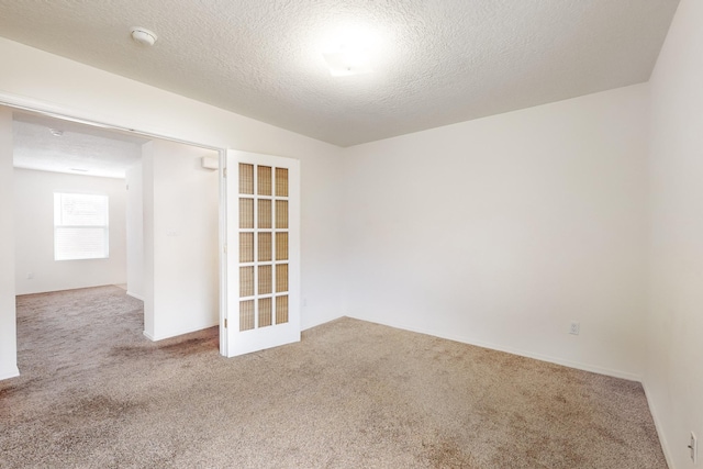 empty room with carpet flooring and a textured ceiling