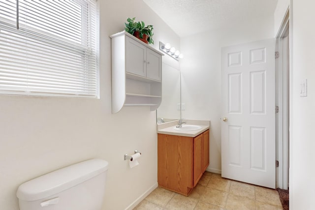 bathroom featuring a textured ceiling, toilet, and vanity