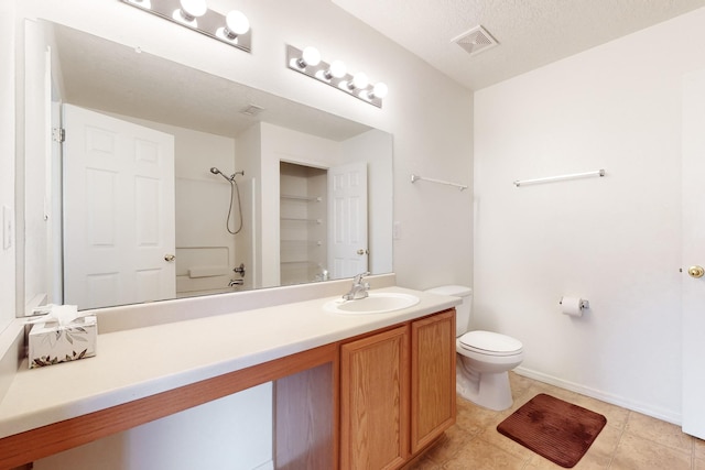 bathroom featuring vanity, toilet, walk in shower, and a textured ceiling