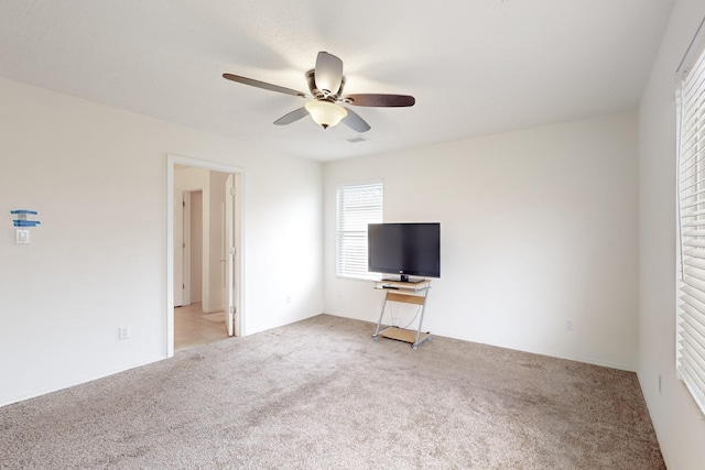 unfurnished living room featuring light carpet and ceiling fan