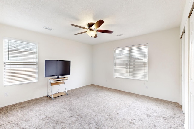 unfurnished living room with a healthy amount of sunlight and carpet flooring