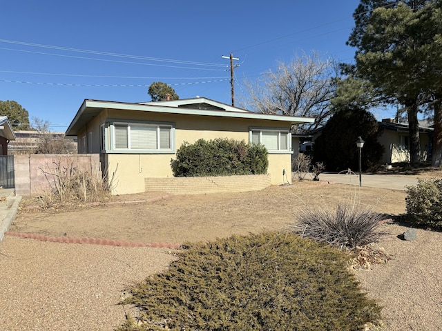 view of side of property with fence and stucco siding