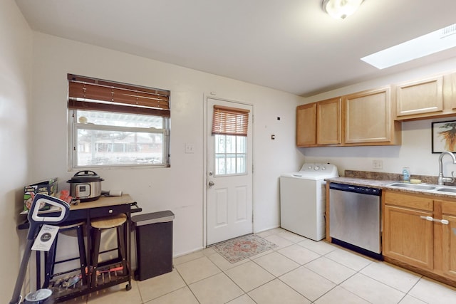 laundry room with washer / clothes dryer, a skylight, sink, and light tile patterned floors