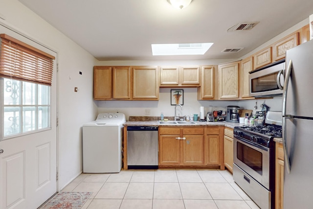 kitchen featuring washer / clothes dryer, sink, light tile patterned flooring, appliances with stainless steel finishes, and light brown cabinetry