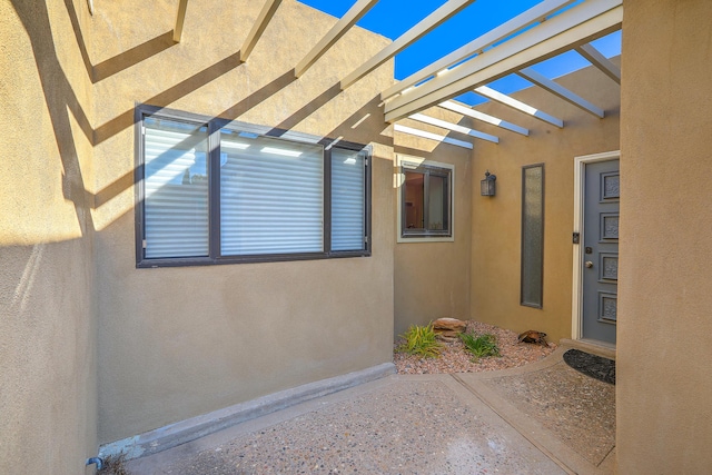 view of exterior entry featuring a pergola