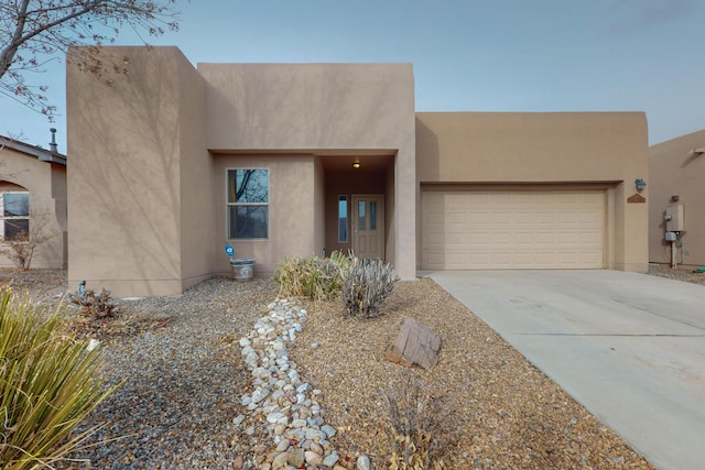 pueblo revival-style home featuring a garage