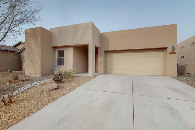 pueblo revival-style home with a garage