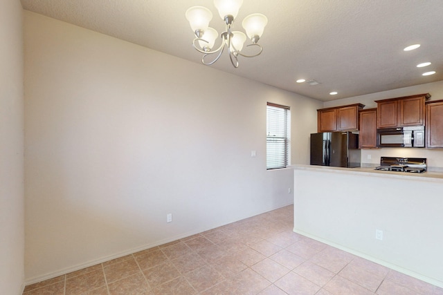 kitchen with black appliances, hanging light fixtures, and a chandelier