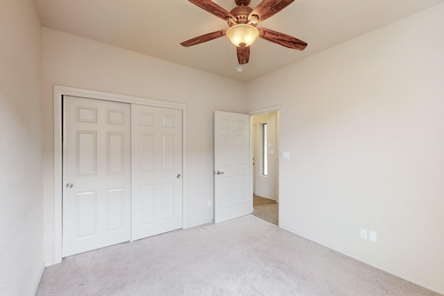 unfurnished bedroom with ceiling fan, a closet, and light carpet