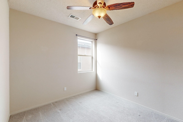 carpeted spare room featuring ceiling fan and a textured ceiling