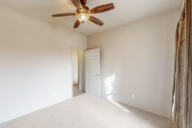 unfurnished room with ceiling fan and light carpet