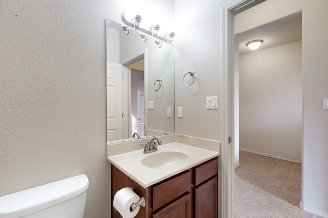 bathroom featuring vanity, toilet, and a textured ceiling