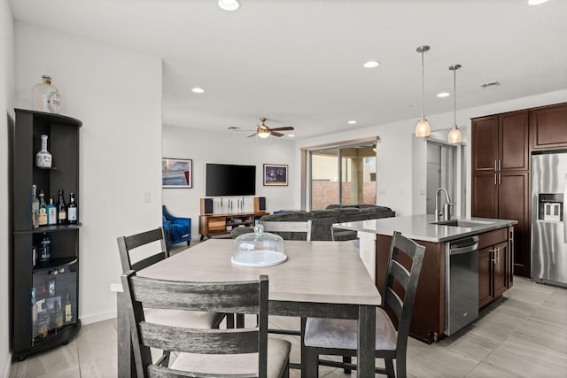 tiled dining room with ceiling fan and indoor wet bar