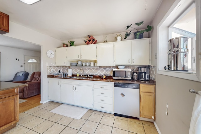 kitchen with stainless steel appliances, light tile patterned flooring, white cabinets, and sink