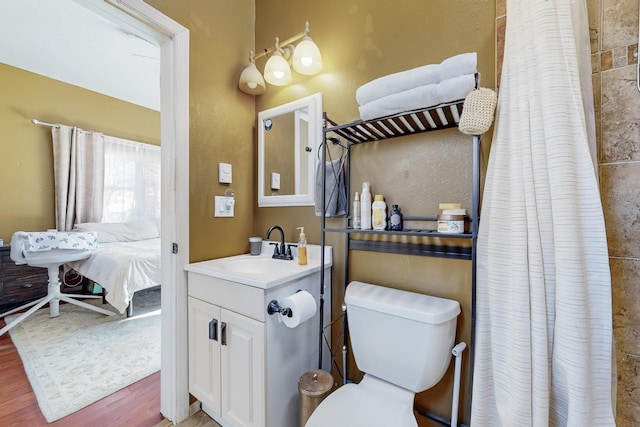 bathroom featuring walk in shower, toilet, vanity, and hardwood / wood-style flooring