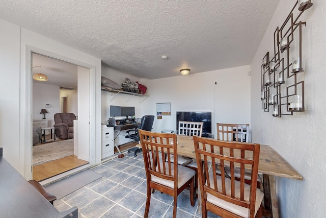 dining area featuring a textured ceiling