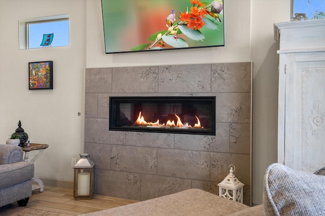 interior space with a tiled fireplace and hardwood / wood-style floors