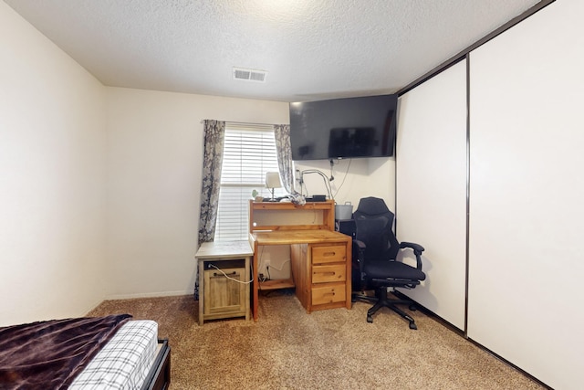 carpeted bedroom featuring a textured ceiling and a closet