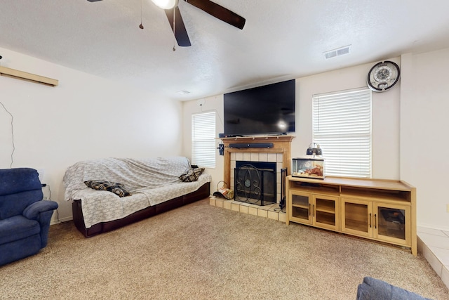 living room featuring a wealth of natural light, carpet, a textured ceiling, and ceiling fan