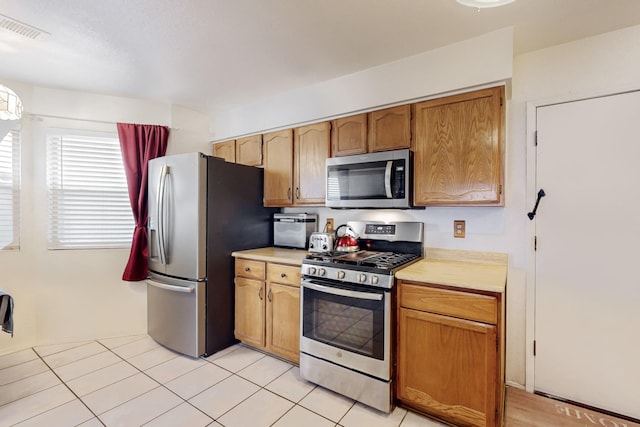 kitchen featuring light tile patterned floors and appliances with stainless steel finishes