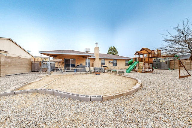 rear view of property with a playground