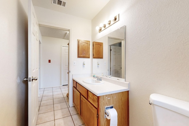 bathroom featuring tile patterned flooring, vanity, and toilet