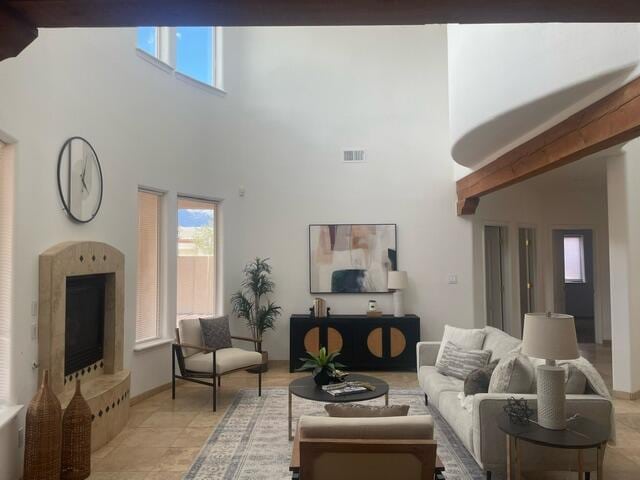 living room featuring healthy amount of natural light, a towering ceiling, and baseboards