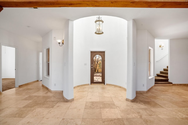 foyer entrance featuring stairs and baseboards