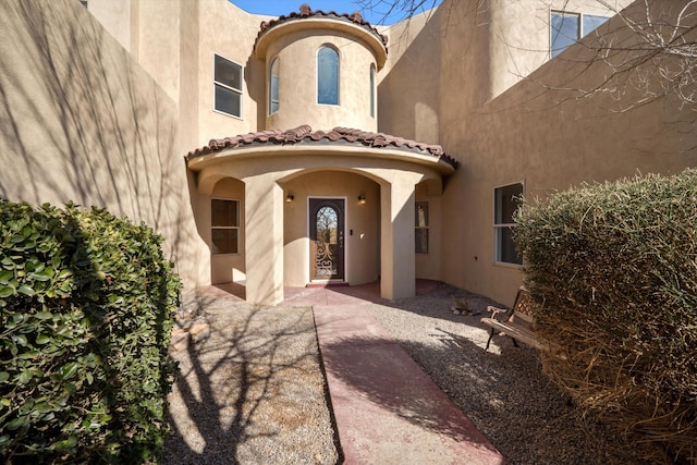 property entrance featuring stucco siding and a tiled roof