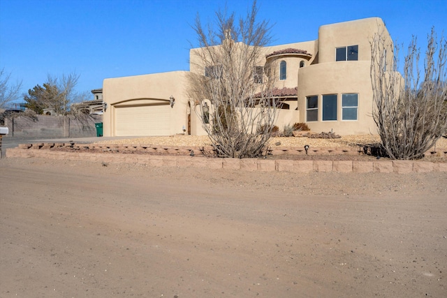 pueblo revival-style home featuring a garage