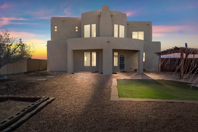 back of house with a patio area, stucco siding, a fenced backyard, and a pergola