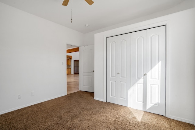 unfurnished bedroom with carpet floors, baseboards, a closet, and ceiling fan