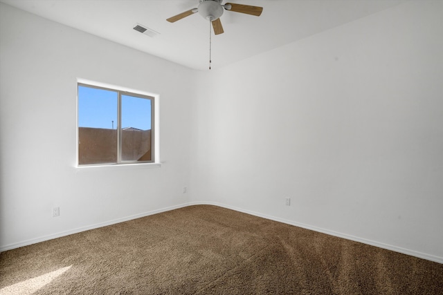 unfurnished room with dark carpet, a ceiling fan, and baseboards