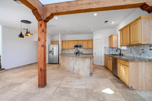 kitchen featuring sink, light brown cabinets, tasteful backsplash, an island with sink, and appliances with stainless steel finishes