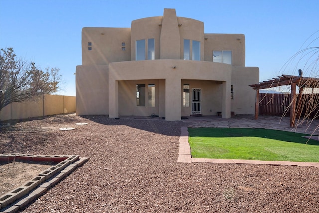 rear view of property featuring a patio, a yard, and a pergola