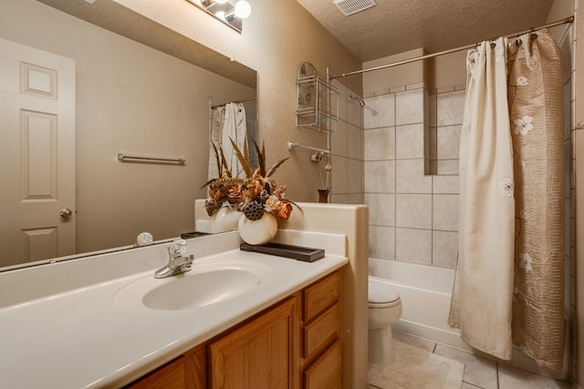 full bathroom with tile patterned floors, a textured ceiling, toilet, shower / bath combo with shower curtain, and vanity