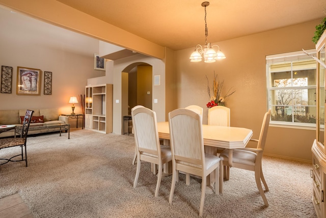 dining space featuring light colored carpet and a notable chandelier