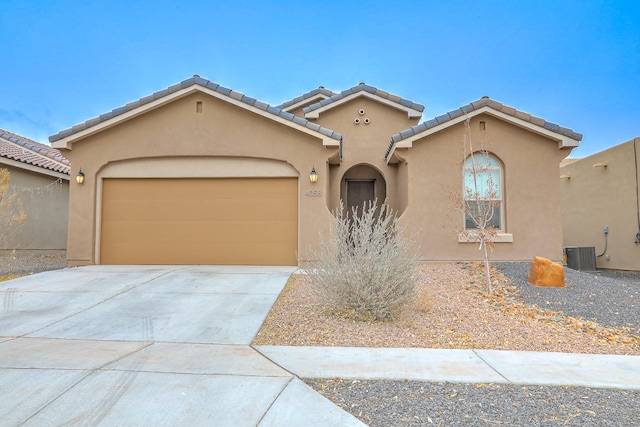 view of front of home with a garage and central air condition unit