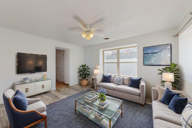 bedroom featuring light wood-type flooring, ceiling fan, and a textured ceiling