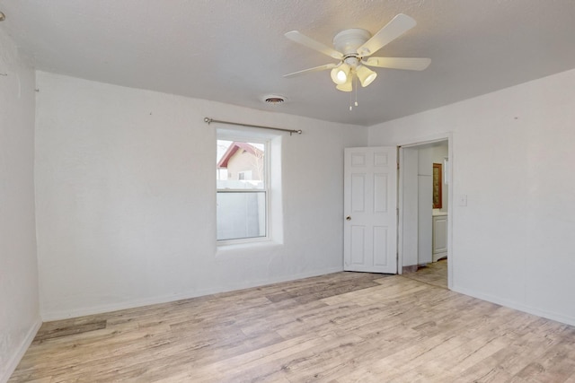 spare room with ceiling fan and light wood-type flooring