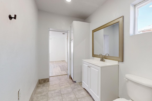 bathroom with toilet, tile patterned flooring, and vanity