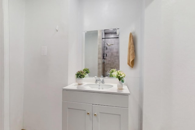 bathroom featuring a tile shower and vanity