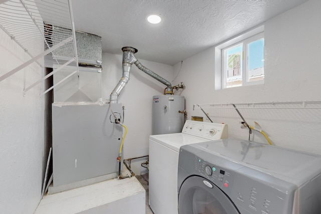 washroom featuring gas water heater, heating unit, a textured ceiling, and independent washer and dryer