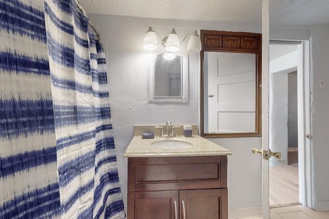 bathroom featuring tile patterned flooring, vanity, and a textured ceiling