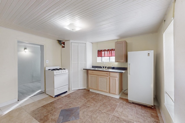 kitchen with light brown cabinetry, white appliances, and sink